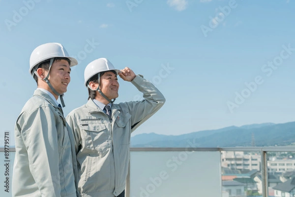 Fototapeta 青空の中に立つ作業服を着た作業員（建設・建築・設計・不動産・土木・工事・現場監督・運送）
