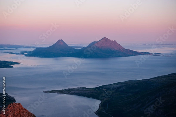 Fototapeta Midnight sun sunset view over Tomma island, in the archipelagio of Northern Norway, Helgeland. Smaltind, Breitind and Tortenviktind in the foreground.