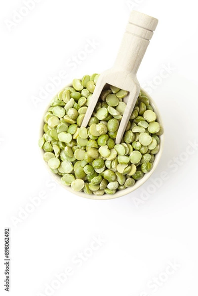 Fototapeta Dry, green peas in bowl with wooden scoop on white background. Top view. Space for a text
