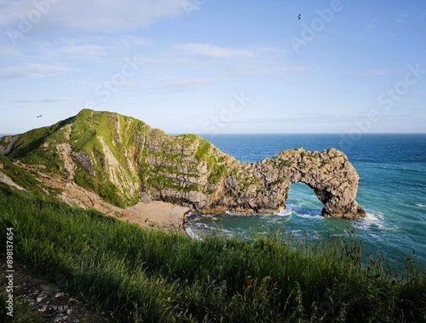 Fototapeta Capture the breathtaking beauty of Durdle Door and Man O'War Beach on the Jurassic Coast, UK. This stunning view showcases the iconic limestone arch, coastal cliffs, and serene beachscape.