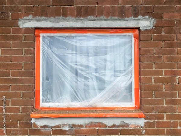 Obraz House renovation - brick built 1960's house with new lintel over window and plastic protection over window.