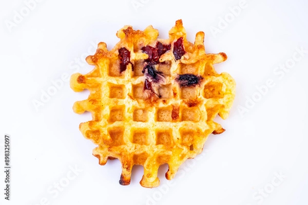 Fototapeta Homemade waffles. Soft waffles with died fruits on a white background.