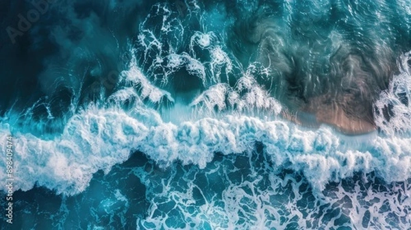 Fototapeta Aerial view of ocean waves breaking, creating a turquoise and white abstract pattern.