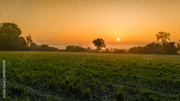 Obraz Bocage normand baignant dans une lumière jaune orange rouge sous le soleil levant