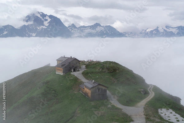 Fototapeta alpine hut on a mountain above the clouds