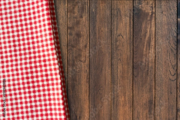 Fototapeta Top view of red gingham checkered table cloth on old wooden table background. Picnic napkin kitchen backdrop.