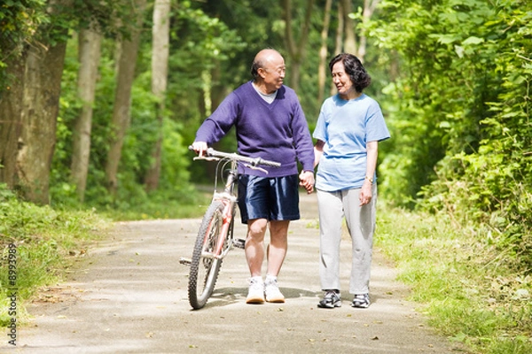 Obraz A couple senior asian talking and exercising at a park