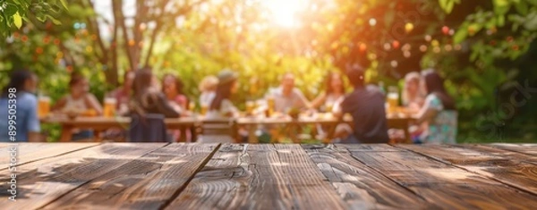 Obraz Empty wooden table and blurred view of a group of people having BBQ barbecue outdoors. Wood desk in front of a natural garden background. Summer lifestyle concept.