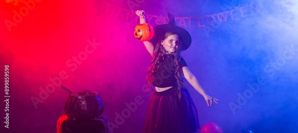 Fototapeta Banner happy laughing child girl in witch costume to Halloween holds jack lantern, copy space