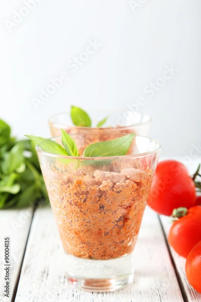 Fototapeta Glass with granita from fresh tomatoes on white wooden backgroun