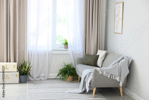 Fototapeta Comfortable sofa and elegant curtains in living room. Interior design