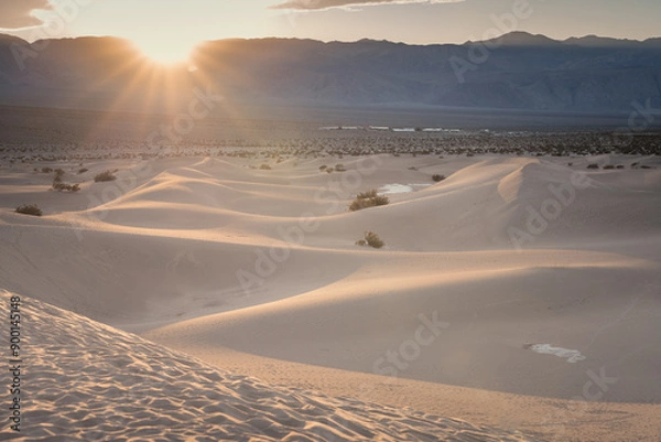 Obraz Sun burst over the mountains on Mesquite Dunes in Death Valley, CA