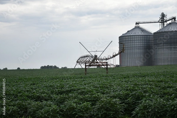 Fototapeta Irrigation System and Grain Bins in a Farm Field