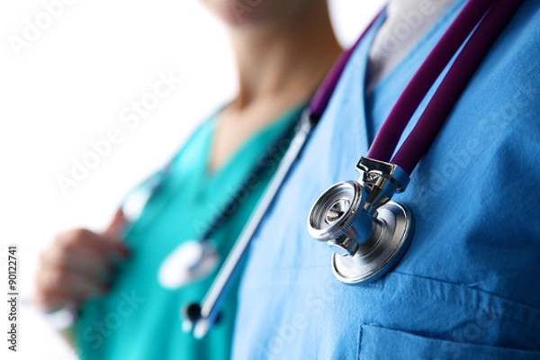Fototapeta young doctor standing with a stethoscope on a white backgro