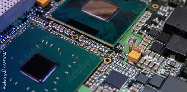 Fototapeta Detailed closeup of an electronic circuit board showcasing microchips, resistors, and other components, representing modern technology and hardware.