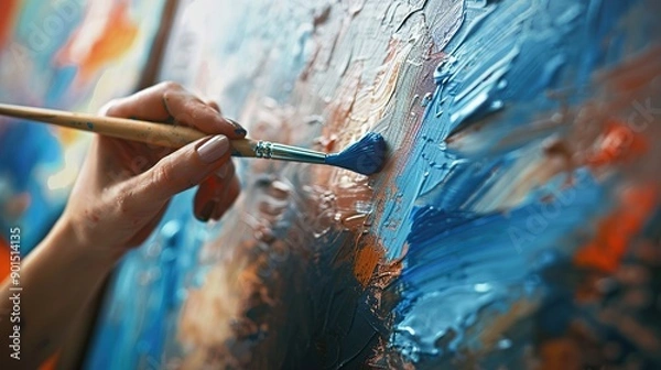 Fototapeta Close-up of an artist's hand painting abstract artwork with brush