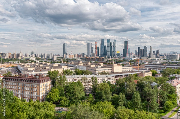 Fototapeta Panoramic view of residential and administrative buildings, the Moscow City district among green trees in the capital city of Moscow from a bird's eye view, aerial view in summer.