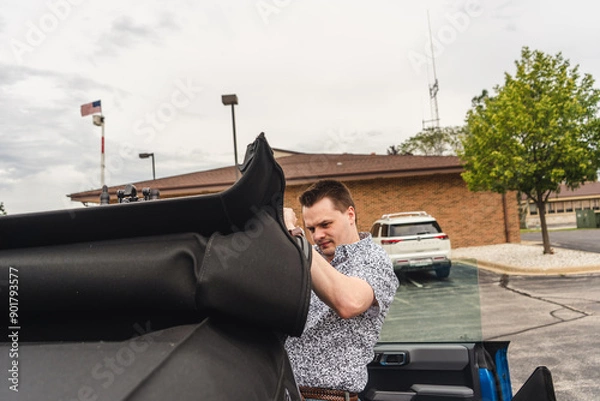 Fototapeta man attempting to put on sunroof