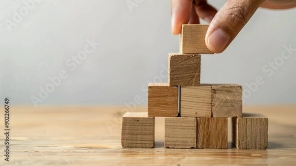Fototapeta Hand Placing Wooden Block on Top of Stack