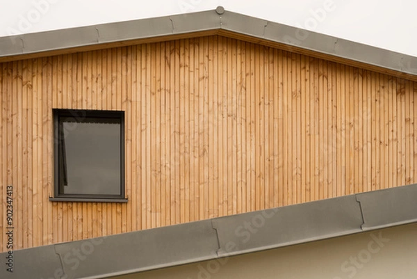 Fototapeta Modern architecture gable with flat roof made of metal titanium zinc and cladding made of untreated natural larch wood