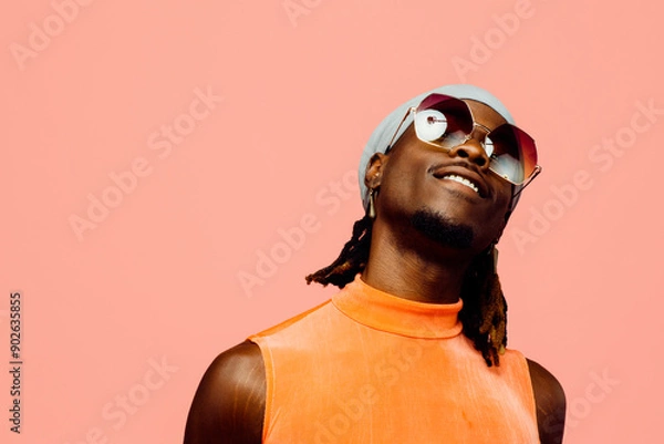 Obraz Portrait of a happy young man with sunglasses and cap laughing, isolated on pink