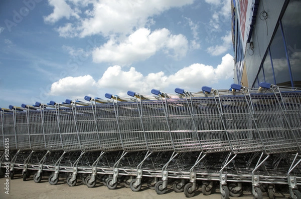 Obraz A lot of blue trolleys standing together