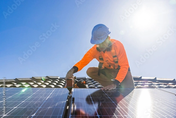 Obraz Solar panel technician with drill installing solar panels
