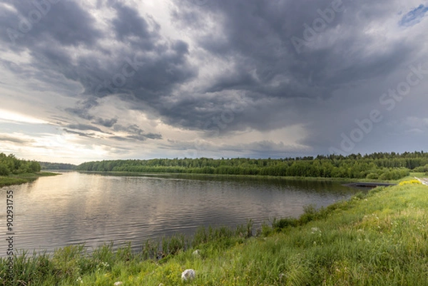 Fototapeta A lake with a cloudy sky in the background