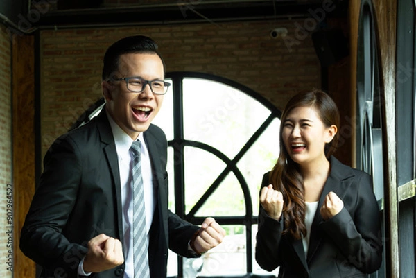 Fototapeta Young business couple working and discussing, business people working on project together in modern coffee shop background. Brainstorming at coffee break out of the office.