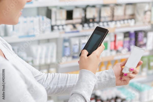 Fototapeta Close up a woman taking picture of product in drugstore