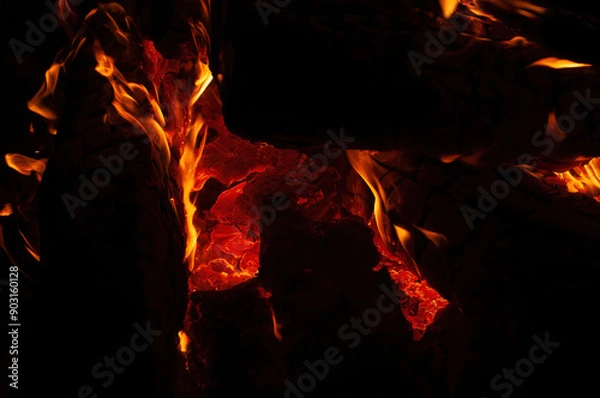 Obraz A roaring fire burns brightly in the dark, with dynamic orange and yellow flames that highlight the intense heat and captivating beauty of a blaze.