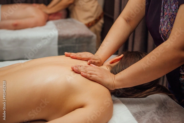 Obraz Close-up of masseur's hands massaging a client's shoulders with oil