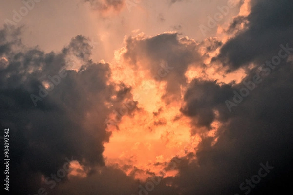 Fototapeta 黒い雲に隠されたオレンジ色の太陽