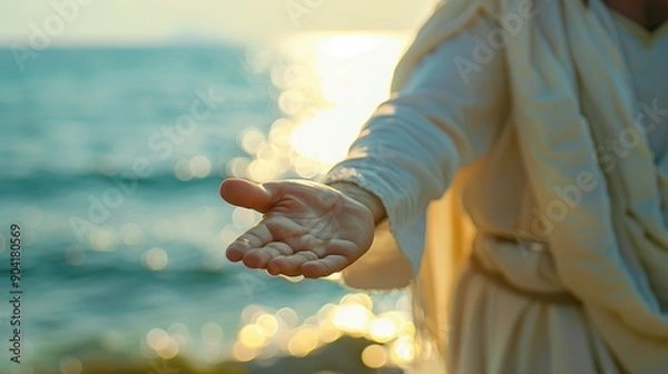 Fototapeta Jesus in White Robe Extending an Open Hand by a Sunlit Sea at Sunset