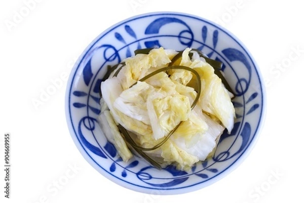 Fototapeta A close up shot of Japanese style pickled Chinese cabbage on a porcelain plate on white background.