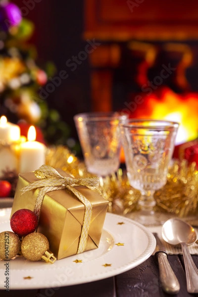 Fototapeta Christmas table with a fireplace in the background.