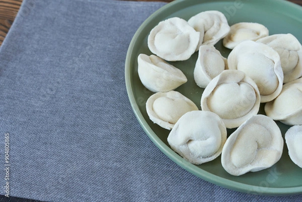 Obraz Homemade dumplings on a green plate on a gray background