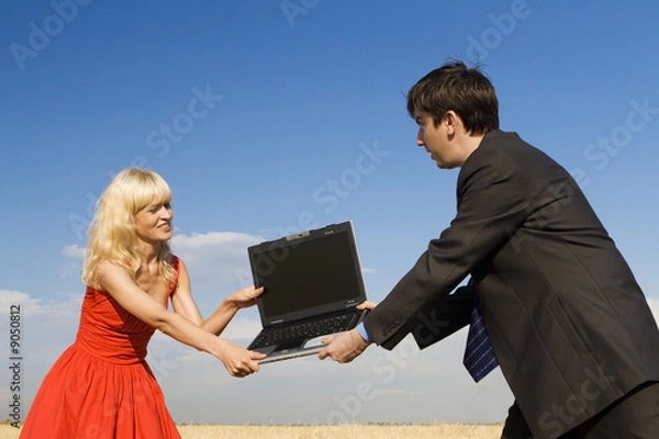 Fototapeta businessman and lady in red fighting for notebook