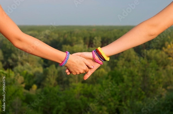 Fototapeta two children's hands with bracelets