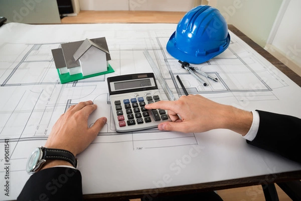 Fototapeta Architect With Blueprint Calculating On Calculator
