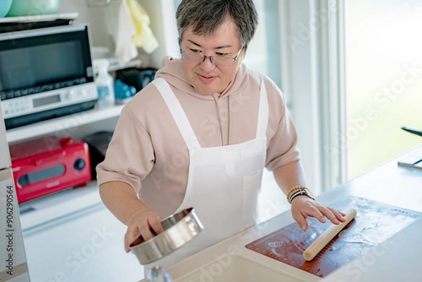 Fototapeta キッチンで作業する中年男性