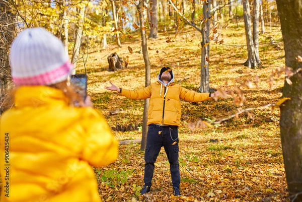 Fototapeta Father and Daughter Enjoying a Colorful Autumn Day in the Park While Playing With Fallen Leaves