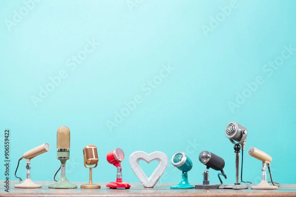 Obraz Retro microphones and concrete heart on table front gradient mint blue background. Vintage old style filtered photo