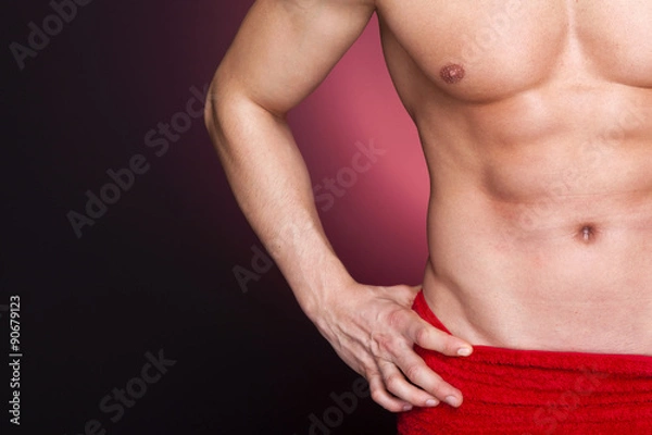 Fototapeta Fit man in red towel against dark background
