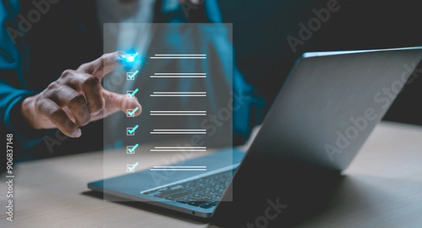 Obraz Businessman using laptop doing online checklist survey, Business performance checklist, filling out digital form checklist, take an assessment, questionnaire, evaluation, online survey.	