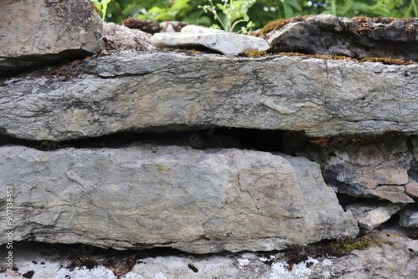 Obraz Gray stone blocks with soil and plants.

