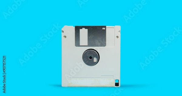 Obraz old white plastic square computer floppy disk on a blue surface against blue background