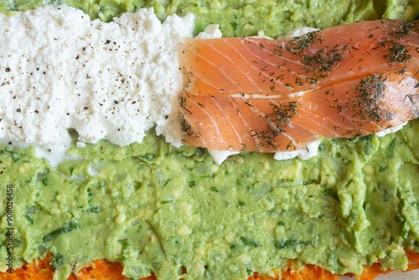 Fototapeta A close-up view of a delicious and healthy dish featuring smoked salmon, fresh ricotta cheese, and creamy guacamole. The vibrant colors and textures create an appetizing presentation. Healthy food.