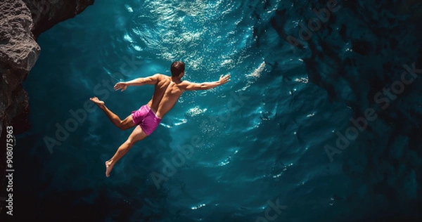Fototapeta Atemberaubender Moment des Klippenspringens an einem sonnigen Tag über glitzerndem Wasser