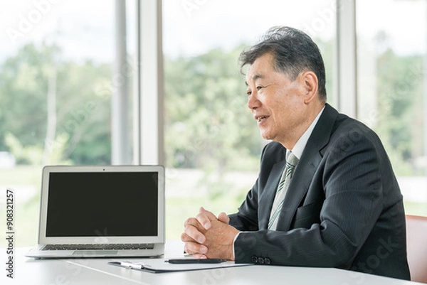Fototapeta 接客・カウンセリング・面談するスーツ姿のアジア人シニア男性ビジネスマン
